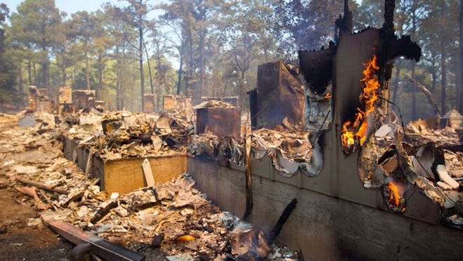 The remains of a house in Tahitian Village smolders on Monday Sept. 5, 2011. FILE PHOTO