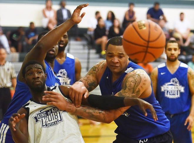 CNY Sealcoating's Jalen Hawkins, left, fights for possession of the ball with former Syracuse University center DaJuan Coleman of the Rim Rockers during Monday night's opener of the King of Kings Summer Basketball League at Mohawk Valley Community College. [SARAH CONDON/OBSERVER-DISPATCH]