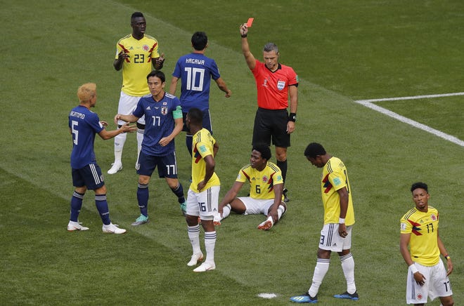 Referee Damir Skomina from Slovenia shows a red card to Colombia's Carlos Sanchez, on the ground, during the group H match between Colombia and Japan at the 2018 soccer World Cup in the Mordavia Arena in Saransk, Russia, Tuesday, June 19, 2018. (AP Photo/Vadim Ghirda)
