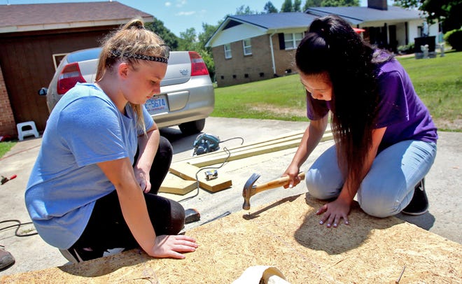 From left, Samantha Carter, 13, and Jessie McCalister, 15, take turns hammering while building a ramp with Carolina Cross Connection on Tuesday. [Brittany Randolph/The Star]