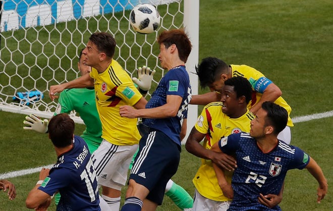 Japan's Yuya Osako, center, scores his side second goal during the group H match between Colombia and Japan at the 2018 soccer World Cup in the Mordavia Arena in Saransk, Russia, Tuesday, June 19, 2018. (AP Photo/Vadim Ghirda)