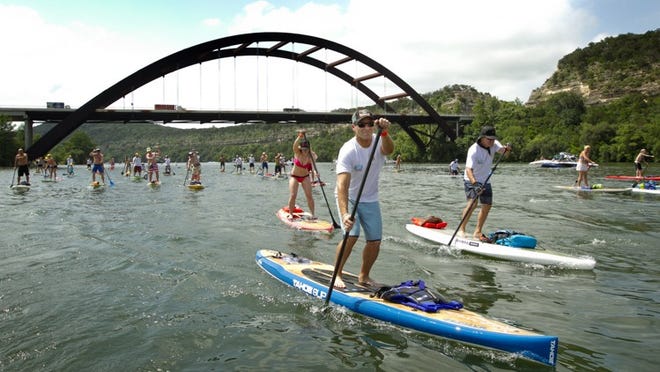 Stand-up paddleboarders again will take part in the annual Tyler’s Dam That Cancer event on June 25. The event raises money for the Flatwater Foundation, a nonprofit that provides access to mental health services for those affected by cancer. JAY JANNER / AMERICAN-STATESMAN 2014
