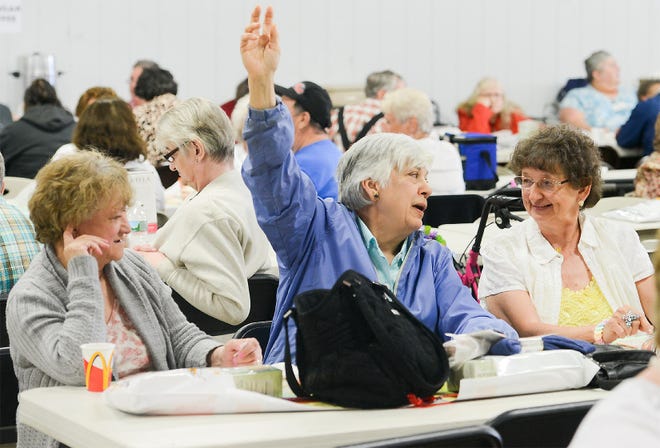 New Hartford resident Sylvia Banas, center, raises her hand and talks to her friend Joan Miller, right, after getting bingo during the Herkimer County Senior Picnic on Wednesday at the Herkimer County Fairgrounds in Frankfort. [ALEX COOPER/OBSERVER-DISPATCH]