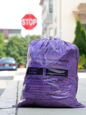 A purple bag used in Fall River's pay-as-you-throw program sits on a sidewalk. [Herald News File Photo | Dave Souza]