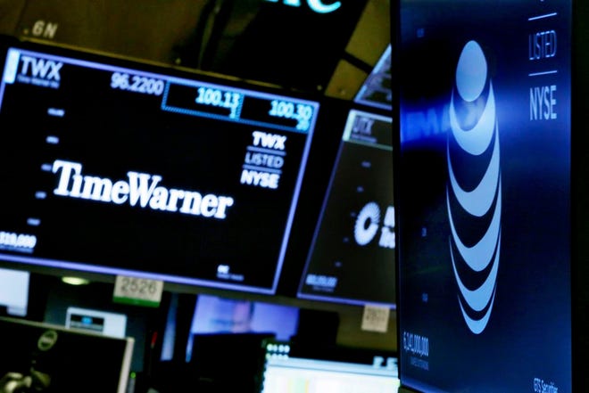FILE - In this Wednesday, June 13, 2018, file photo, the logos for Time Warner and AT&T appear above alternate trading posts on the floor of the New York Stock Exchange. AT&T is launching a new streaming service incorporating networks from the Time Warner company it just bought for $81 billion. Thursday, June 21, announcement comes just days after AT&T closed its Time Warner deal. (AP Photo/Richard Drew, File)