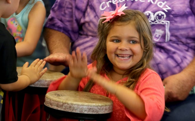 Josie Beam bangs on a drum at the Ruby C. Hunt YMCA Library on Thursday. [Brittany Randolph/The Star]