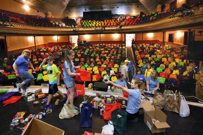 Volunteers keep busy sorting bags of food donations during Fill the Hall event on Saturday at The Music Hall, a local tradition of filling every seat in the iconic theater for Gather's Meals 4 Kids Program. [Ioanna Raptis/Seacoastonline]