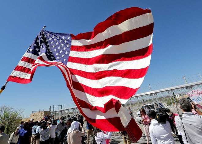 FILE - In this June 21, 2018 file photo, protesters and media gather outside a closed gate at the Port of Entry facility, where tent shelters are being used to house separated family members in Fabens, Texas. The tumult of the past week along the southern border crystalized how the GOP has shifted from the “compassionate” conservatism George W. Bush articulated to win the presidency twice, buoyed by the support of 44 percent of Latinos in 2004. Instead, wrenching photos and audio of the U.S. government separating migrant children from their parents symbolize the tense relationship between Latinos and the White House in the Trump era. (AP Photo/Matt York, File)