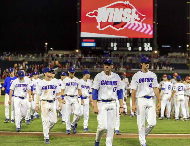 Florida players return to the dugout Friday night following the College World Series game lost to Arkansas in Omaha, Neb. (AP Photo/Nati Harnik)