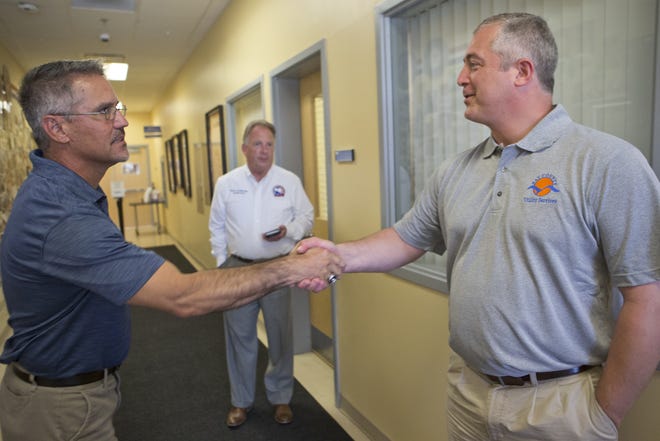Keith Baker, left, who has won a County Commission seat unopposed, shakes hands with incumbent Robert Carroll. As Friday’s qualifying deadline passed, both remained unopposed for the county’s District 4 and District 2 seats. Baker is the director of Panama City Leisure Services. [JOSHUA BOUCHER/THE NEWS HERALD]