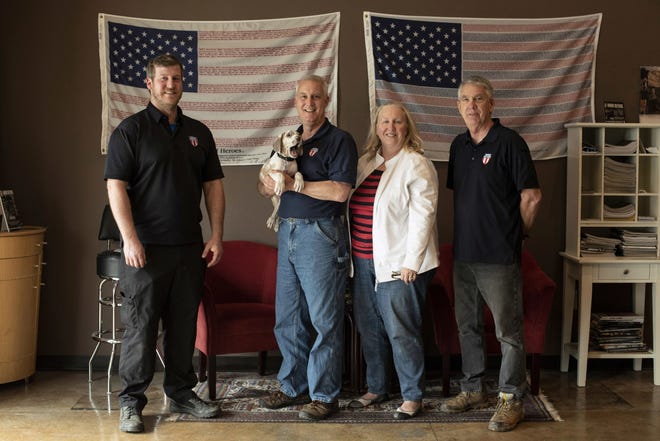In this April 25, 2018 photo, the owners and employees of Honor Defense, a gunmaker in Gainesville, Georgia, pose in the company's lobby. Standing, left to right, are Pete Ramey, who works on the assembly line, Gary Ramey, the company's owner, his wife and company business manager, Pam Ramey, and Richard Moore, who works on the assembly line. The gun industry is finding corporate America distancing itself from gunmakers and gun dealers, discontinuing discounts or refusing business. (AP Photo/Lisa Marie Pane)
