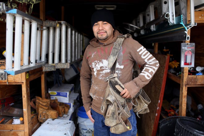 Newly naturalized U.S. citizen Tito Garcia, who owns and operates Garcia Roofing, is shown inside his work trailer Jan. 23, 2018 on a job site in West Burlington. [John Lovretta/thehawkeye.com]