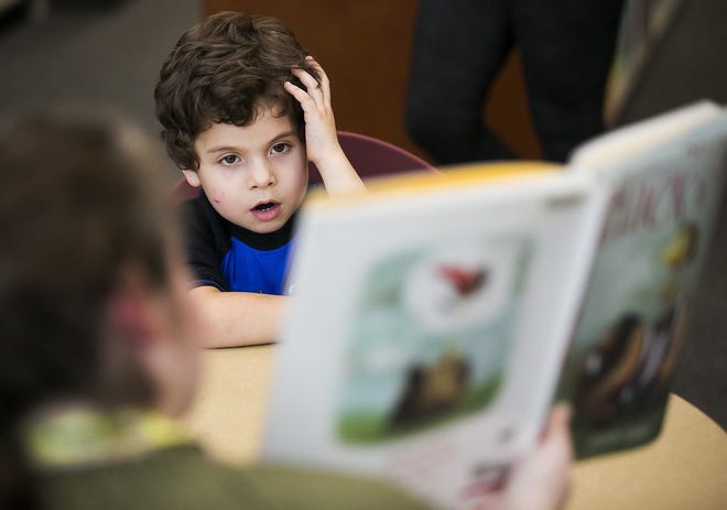 John-Allan Kovacevic, 5, listens as "Chick 'n' Pug" by Jennifer Sattler is read to him earlier this year. Reading continues to be a challenge for Marion County schools and Superintendent Heidi Maier is rolling out a new reading initiative to help improve performance by the district's students. [Doug Engle/Ocala Star-Banner]