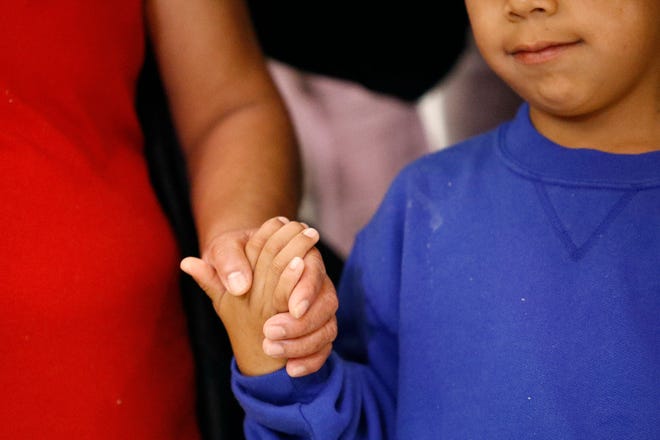 Darwin Micheal Mejia, right, holds hands with his mother, Beata Mariana de Jesus Mejia-Mejia, after their reunion at Baltimore-Washington International Thurgood Marshall Airport on Friday. She has filed for political asylum in the U.S. after a trek from Guatemala. [PATRICK SEMANSKY/AP]
