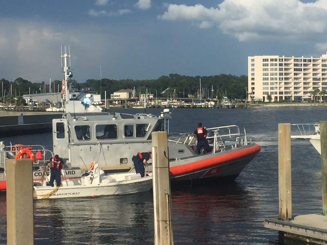 The U.S. Coast Guard tows in a small Aquasport vessel that was spinning by itself for over an hour near the Panama City Marina after its driver fell out and was taken to the hospital. [ERYN DION/THE NEWS HERALD]