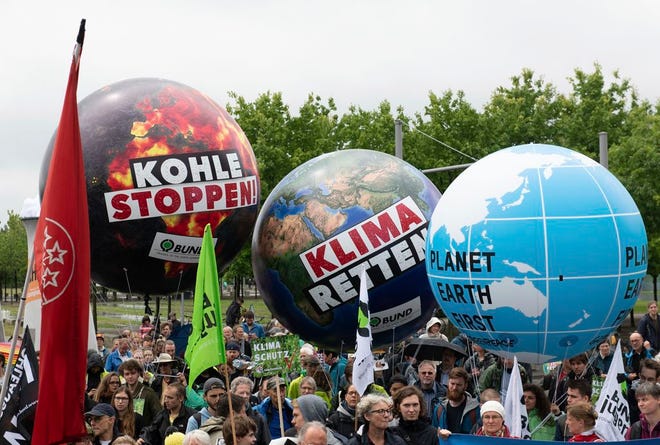 Protestors attend a demonstration demanding the end of burning coal to produce electricity in Berlin, Germany, Sunday, June 24, 2018. The words on the balloons read: 'Stop Coal' and ' Save Climate'. (Paul Zinken/dpa via AP)