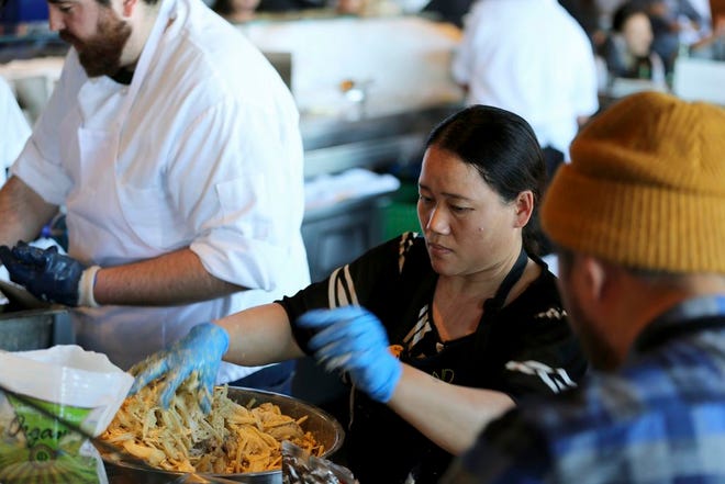 In this photo taken June 19, 2018, Pa Wah, a refugee from Myanmar, mixes shrimp in a turmeric tempura batter at the Hog Island Oyster Co. restaurant in San Francisco during the inaugural Refugee Food Festival. San Francisco restaurants are opening their kitchens for the first time to refugees who are showcasing their culinary skills and native cuisines while raising their profiles as aspiring chefs as part of a program to increase awareness about the plight of refugees worldwide. (AP Photo/Lorin Eleni Gill)