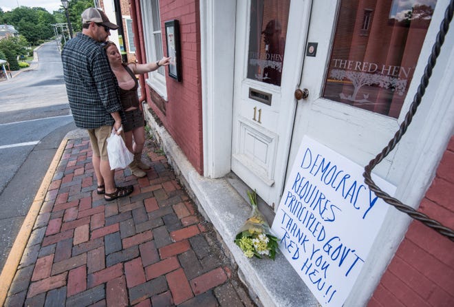 Passersby examine the menu at the Red Hen Restaurant Saturday, June 23, 2018, in Lexington, Va. White House press secretary Sarah Huckabee Sanders said Saturday in a tweet that she was booted from the Virginia restaurant because she works for President Donald Trump. Sanders said she was told by the owner of The Red Hen that she had to "leave because I work for @POTUS and I politely left." (AP Photo/Daniel Lin)/Daily News-Record via AP)