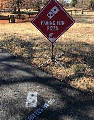 A sign and paint show a pothole fixed through the Paving for Pizza program in Bartonville, Texas. [Submitted photo]