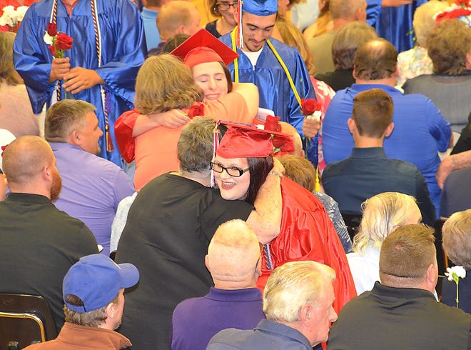 Students and family embrace during the presentation of the roses Saturday. [Stephen Borgna/The Leader]