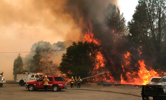 In this photo provided by the Cal Fire Communications, firefighters battle a wildfire in an area northeast of Clearlake Oaks, Calif., Sunday, June 24, 2018 Wind-driven wildfires destroyed buildings and threatened hundreds of others Sunday as they raced across dry brush in rural Northern California. (Jonathan Cox/Cal Fire Communications via AP)