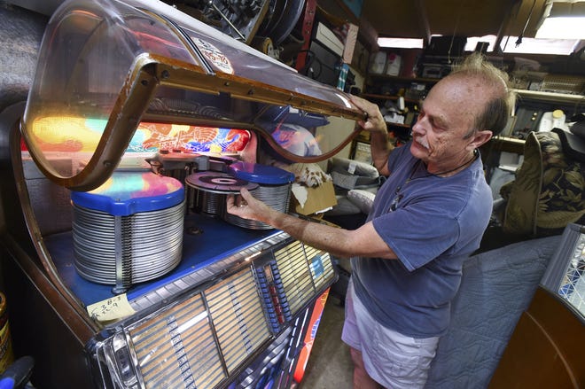 Ross Williams shows off one of the antique jukeboxes he restored at his Fort Walton Beach home. [DEVON RAVINE/DAILY NEWS]