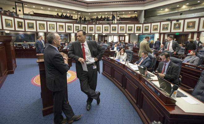 State Sen. Tom Lee, right, R-Brandon, talks with House Speaker Richard Corcoran, R-Land O' Lakes, on the House floor on May 5 at the Florida Capitol in Tallahassee. [AP Photo/Mark Wallheiser]