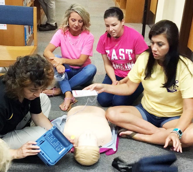 Pink Hill Elementary School faculty practice with a CPR mannequin during recent emergency medical and first aid training that involved about 40 staff members. [Submitted photo]