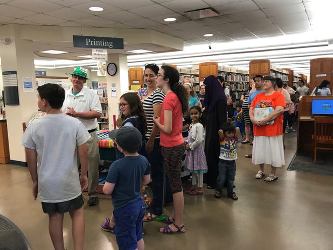 A line formed on the lower level of the Thayer Public Library at the mini golf table where Joe Buckley, of Mobile Mini-Golf handed out putters at the summer reading kick-off event on June 26. Hayley Johnson/The Patriot Ledger