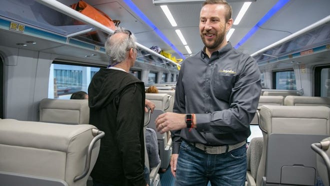 Brightline President and COO, Patrick Goddard walks through the train cars greeting passengers headed from Miami to West Palm Beach, May 19, 2018. (Greg Lovett / The Palm Beach Post)