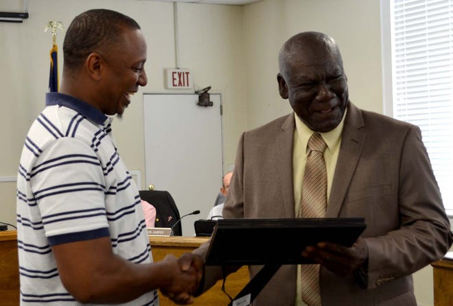 County Councilman Harold Buckmon (right) chuckles at a fun memory of Hersey Graham as he presents a resolution to Hersey's son honoring the late road foreman for the county. [Laura McKenzie / Publisher]