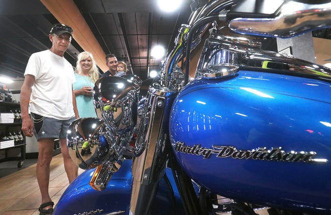 Harley-Davidson enthusiast James Henry, at left, traveled from Germany to see the selection of motorcycles at Bruce Rossmeyer's Harley-Davidson at Destination Daytona. The impact of potential tariffs "ain't gonna bother me none," said Henry, pictured with wife, Sonja; son-in-law Guido Kamp; and granddaughter Elies. [News-Journal/David Tucker]