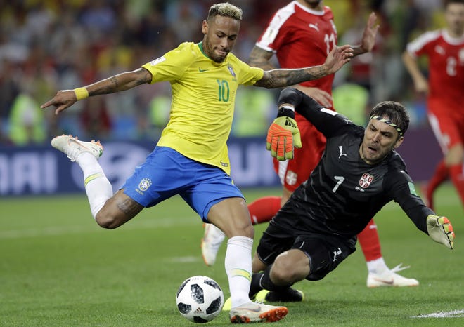 Brazil's Neymar, left, attempts to shoot past Serbia goalkeeper Vladimir Stojkovic during Wednesday's group stage match at the World Cup in Moscow, Russia. [Andre Penner/AP]