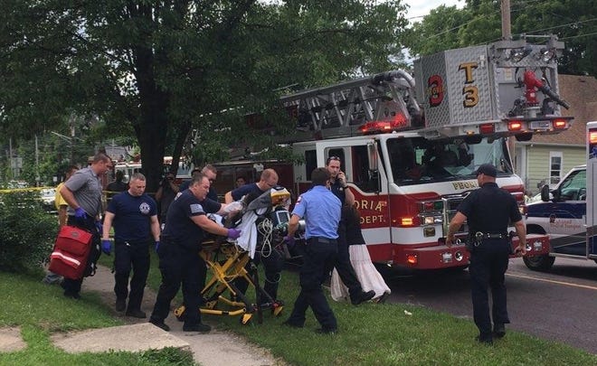 KELSEY WATZNAUER/Journal Star A shooting victim is brought out on a stretcher Tuesday afternoon in the 800 block of West McClure Avenue.