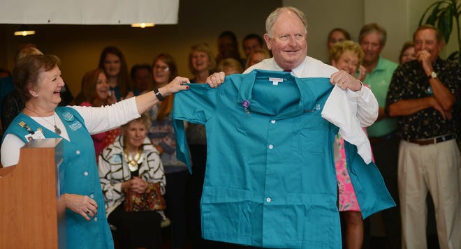 Gary Black, retired UNC Lenoir Health Care President, unveils his gift presented by Yvonne Jones, UNC Lenoir Health Care Volunteers president, as the hospital held "Gary Day" on Wednesday to celebrate Black's retirement. [Janet S. Carter / The Free Press]