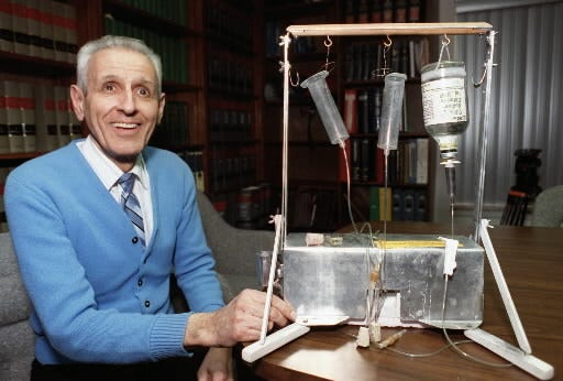 FILE PHOTO: Dr. Jack Kevorkian, who pioneered the physician-assisted suicide movement, poses with his "suicide machine" in Michigan, Feb. 6, 1991.
