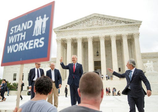 Illinois Gov. Bruce Rauner gives a thumbs up outside the Supreme Court, Wednesday, June 27, 2018 in Washington. From left are, Liberty Justice Center's Director of Litigation Jacob Huebert, plaintiff Mark Janus, Rauner, and Liberty Justice Center founder and chairman John Tillman. The Supreme Court ruled Wednesday that government workers can't be forced to contribute to labor unions that represent them in collective bargaining, dealing a serious financial blow to organized labor. (AP Photo/Andrew Harnik)