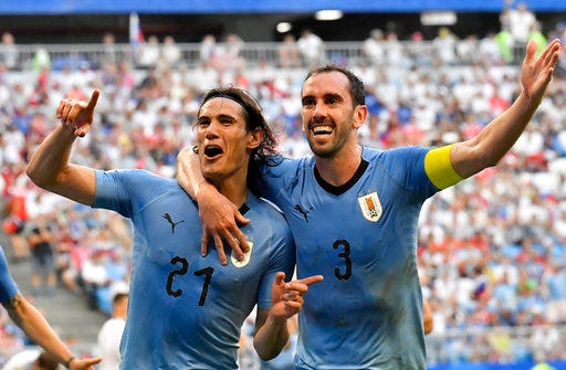 Uruguay's Edinson Cavani celebrates with teammate Diego Godin, right, after scoring his team's third goal during the group A match between Uruguay and Russia at the 2018 soccer World Cup at the Samara Arena in Samara, Russia, Monday, June 25, 2018. (AP Photo/Martin Meissner)