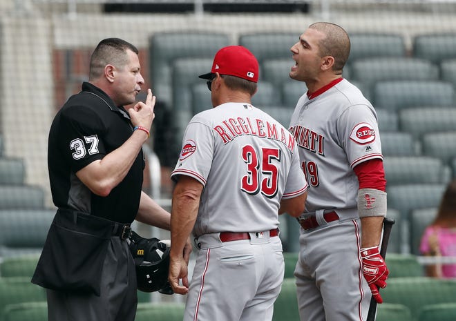 Cincinnati Reds interim manager Jim Riggleman stands between first baseman Joey Votto, right, and umpire Carlos Torres, left, as they argue after Votto was ejected against the Atlanta Braves Wednesday [AP PHOTO/JOHN BAZEMORE]