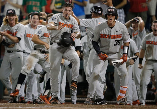 Oregon State's Cadyn Grenier and Adley Rutschman (35) wait at home for Trevor Larnach after Larnach hit a two-run home run against Arkansas that scored Grenier during the ninth inning of Game 2 of the College World Series finals in Omaha, Neb., on Wednesday. Oregon State won 5-3. [AP Photo/Nati Harnik]