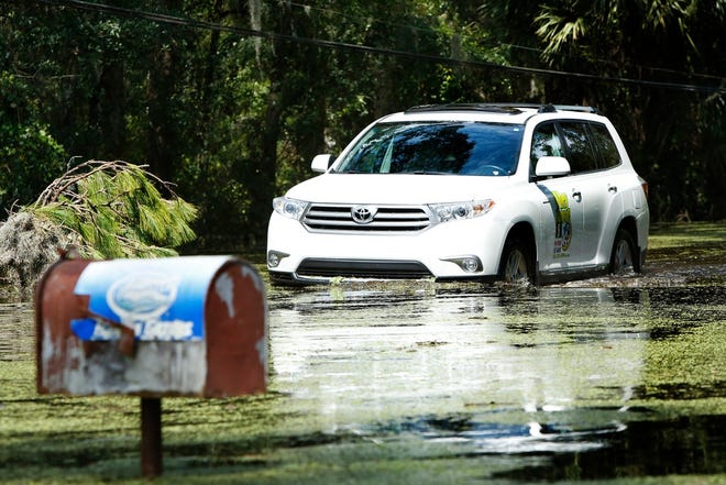 A resident drives through flood waters from Hurricane Irma on Lake Shore Drive in Gainesville in September 2017. [The Gainesville Sun, File]