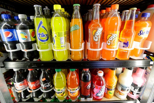 FILE - This Sept. 21, 2016 file photo shows soft drink and soda bottles displayed in a refrigerator at El Ahorro market in San Francisco. The California Legislature is expected to vote to prohibit local governments from creating new taxes on soda on Thursday, June 28, 2018. In exchange, the beverage industry has agreed to drop a ballot measure that would have made it much harder for cities and counties to raise taxes. (AP Photo/Jeff Chiu, File)