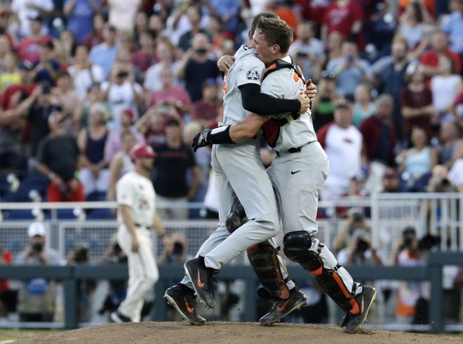 Oregon State pitcher Kevin Abel, left, hugs catcher Adley Rutschman, right, after Oregon State beat Arkansas 5-0 in Game 3 to win the NCAA College World Series on Thursday. [AP photo]