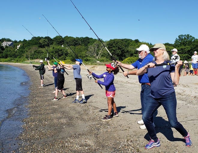 DEM director Janet Coit, right, Steve Medeiros, RI Saltwater Anglers Association president/camp director and campers cast-off to open the third annual RISAA Youth Fishing Camp.