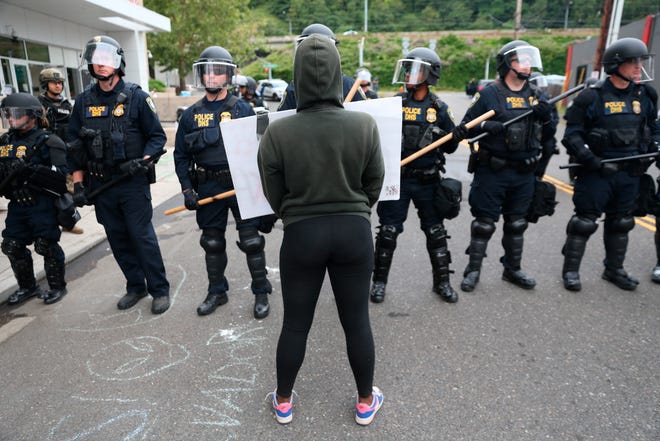 Authorities take action to reopen Portland's Immigration and Customs Enforcement headquarters early Thursday, June 28, 2018. The office has been closed for more than a week because of an occupation by activists. Federal Protective Service spokesman Rob Sperling said in a statement that law enforcement began clearing a camp at sunrise Thursday. (Mark Graves/The Oregonian via AP)