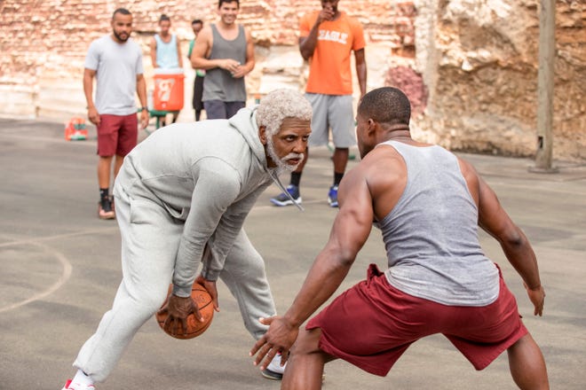 This image released by Lionsgate shows Boston Celtics basketball player Kyrie Irving, left, portraying Uncle Drew in a scene from the comedy "Uncle Drew." (Quantrell D. Colbert/Lionsgate via AP)