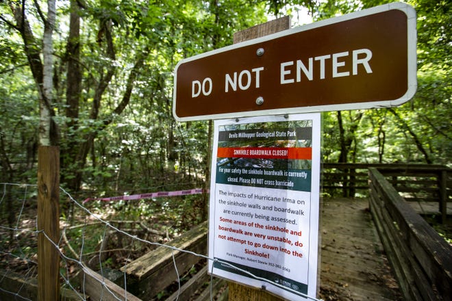 The steps leading down to Devil's Millhopper Geological State Park's boardwalk inside the sinkhole are fenced off Wednesday. 

[Lauren Bacho/Staff Photographer]