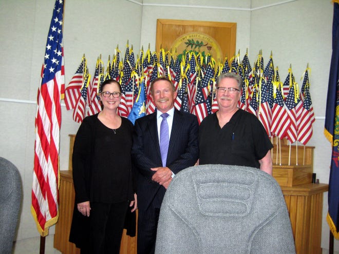 Marie and George Fizel, parents of Air Force Senior Airman Austin Fizel, and Northampton Supervisors Chairman Barry Moore pose at a meeting Wednesday. Austin Fizel, of Holland, was recognized for his recent second deployment with an Air Force flag in the township meeting room display. [Courtesy of Pete Palestina]