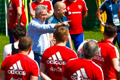 Former Russian national soccer coach Guus Hiddink, center, talks to players besides Russia head coach Stanislav Cherchesov during the official training session of the Russian team prior to the round of 16 match between Russia and Spain at the 2018 soccer World Cup at the Federal Sports Centre Novogorsk, near Moscow, Russia, Thursday, June 28, 2018. (AP Photo/Matthias Schrader)