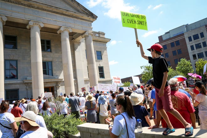 Leo Morrey Hearne, 11, holds a sign during a protest against the Trump administration's immigration policies outside of the Boone County Courthouse on Saturday, June 30, 2018. The protest was part of the Families Belong Together marches, a nationwide movement against the White House's "zero tolerance" policy on immigration. [Hunter Dyke/Tribune]